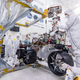 Jet Propulsion Lab engineers install three right-side wheels on the Mars 2020 rover.